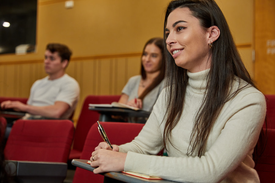 Student sitting down at desk in lecture hall
