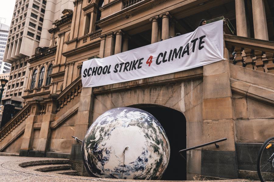 school strike 4 climate change sign above world globe