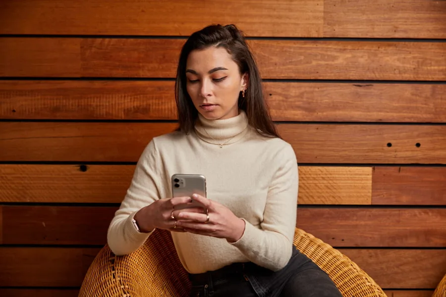 Young woman looking at phone with serious expression