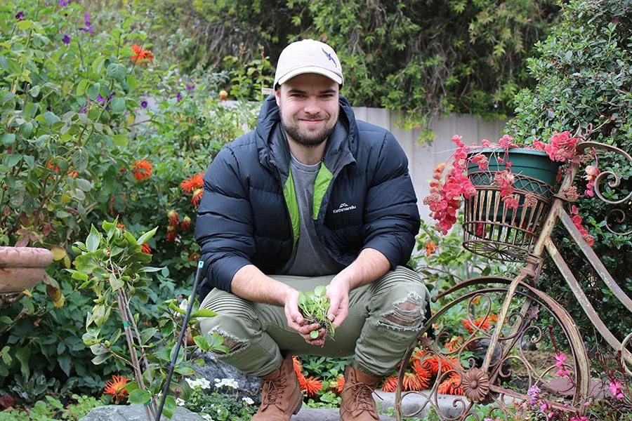 Jack guy kneeling surrounded by garden