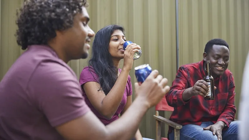 three young people drinking alcohol