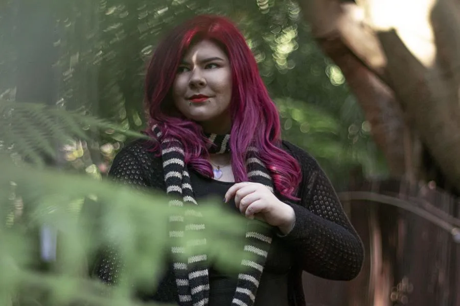 woman with red hair partially hidden in greenery