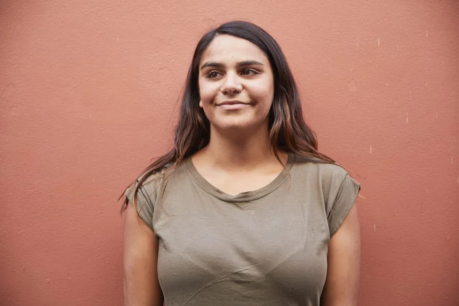 girl leaning against wall smiling