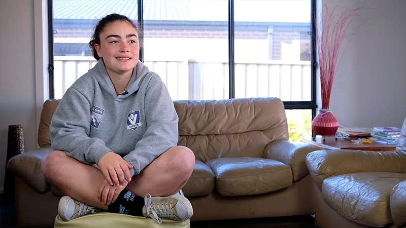 girl in grey hoodie sitting in lounge room