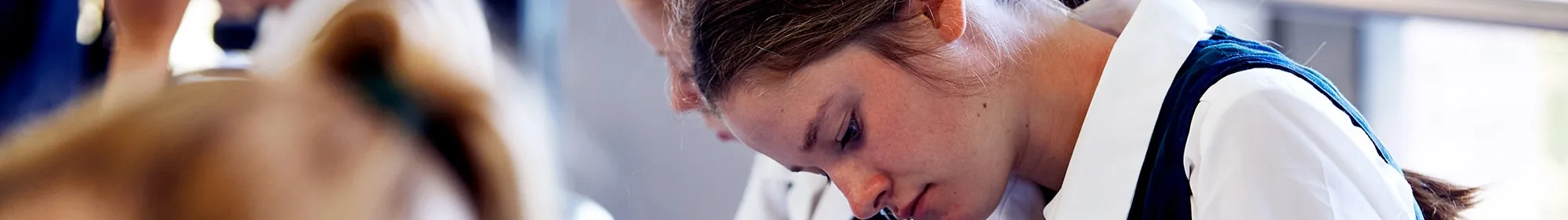 header exam stress girl looking at workbook on desk