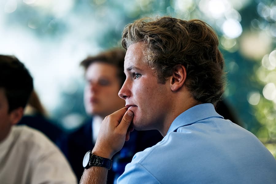 side profile of schoolboy sitting with classmates