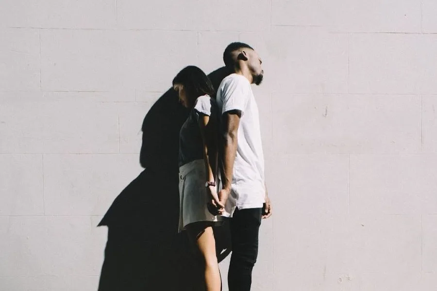 boy and girl holding hands standing and facing away from each other