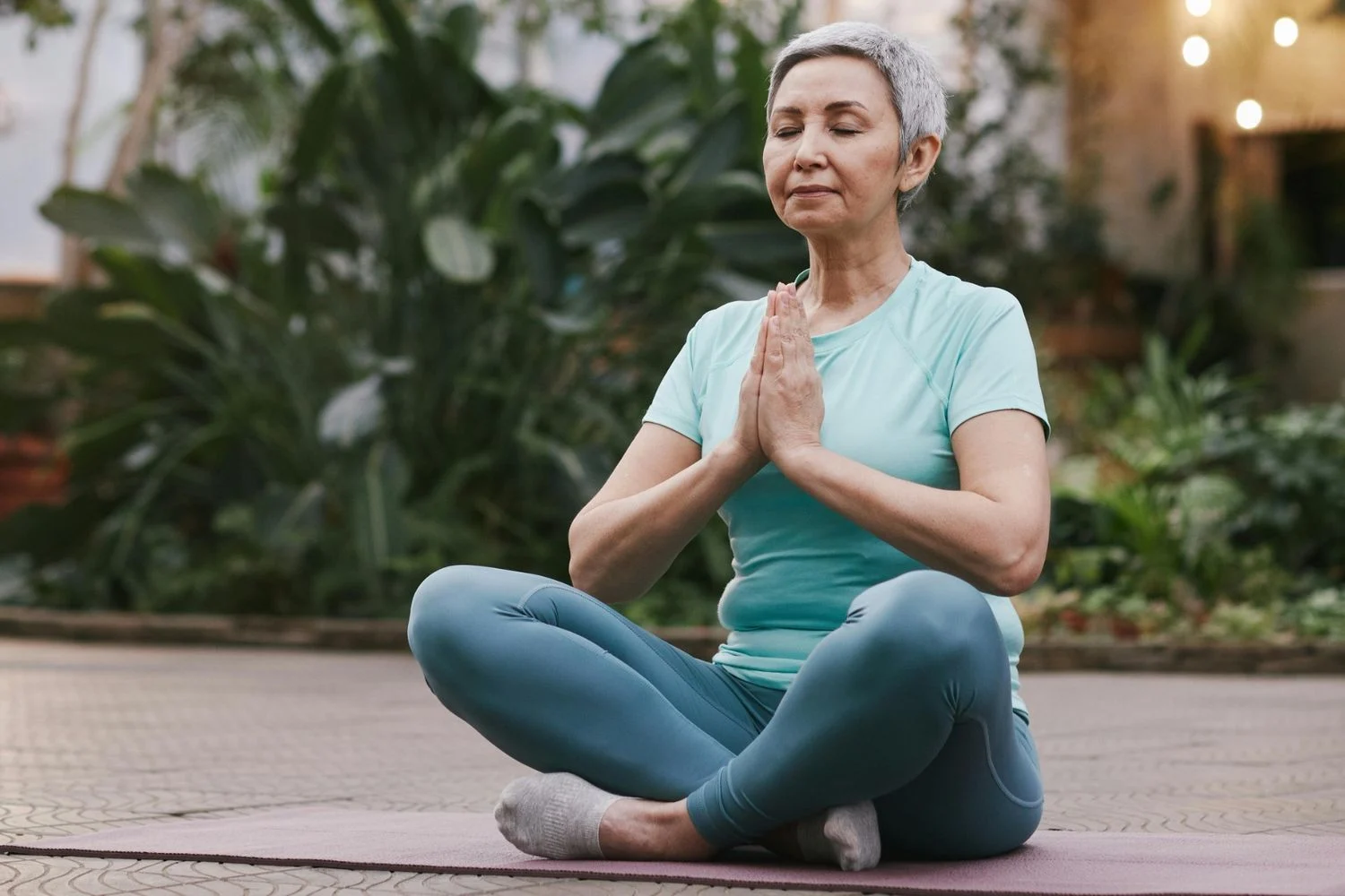 Woman meditating cross-legged on yoga mat