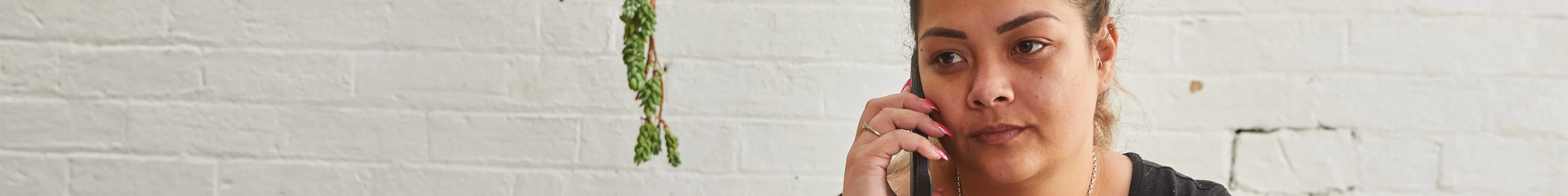 Image of an adult woman holding a mobile phone to her ear.