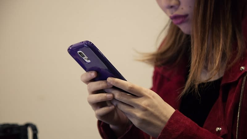 Young woman using purple phone