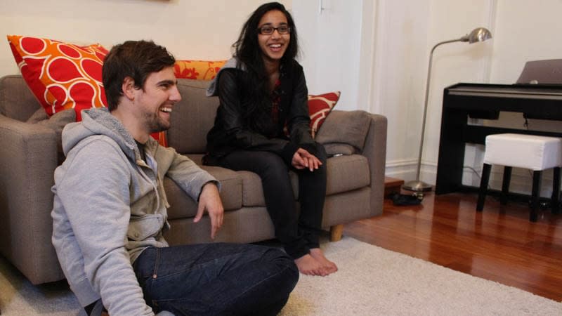 Guy and girl sitting on couch laughing