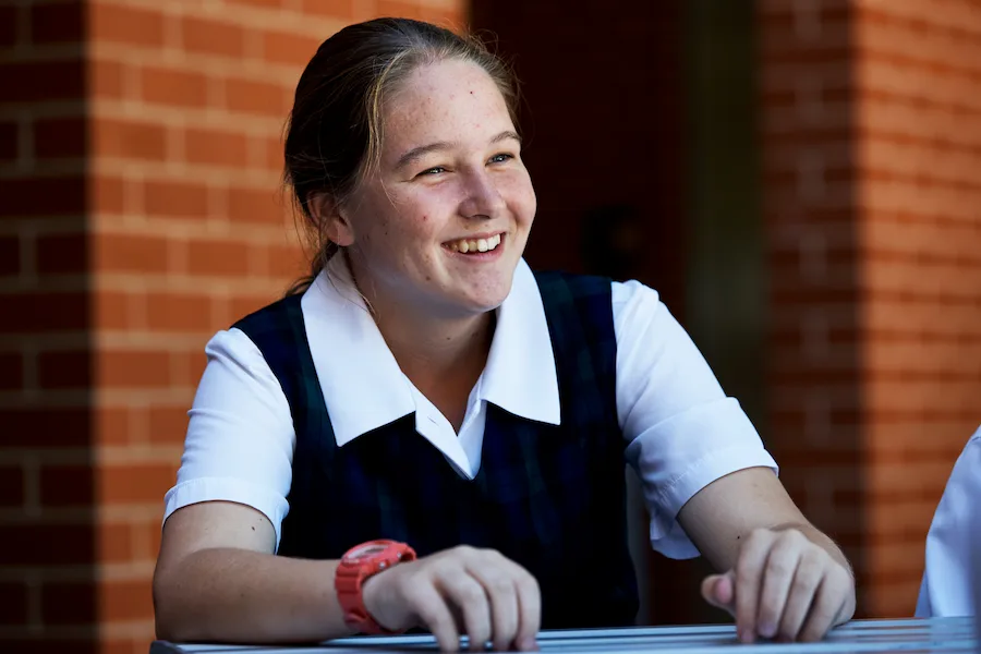 student smiling to the left of camera