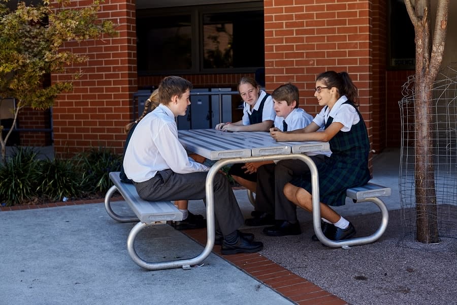 young people in school uniforms at table
