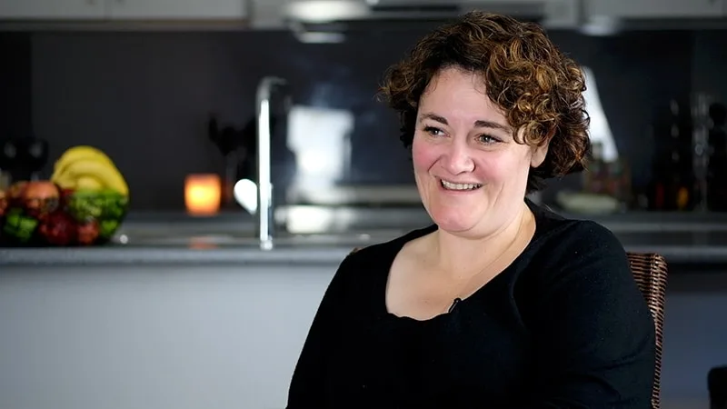 mother with black shirt smiling in kitchen