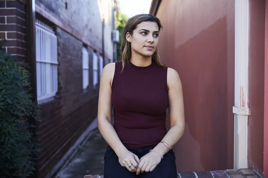 Girl looking anxious sitting outside