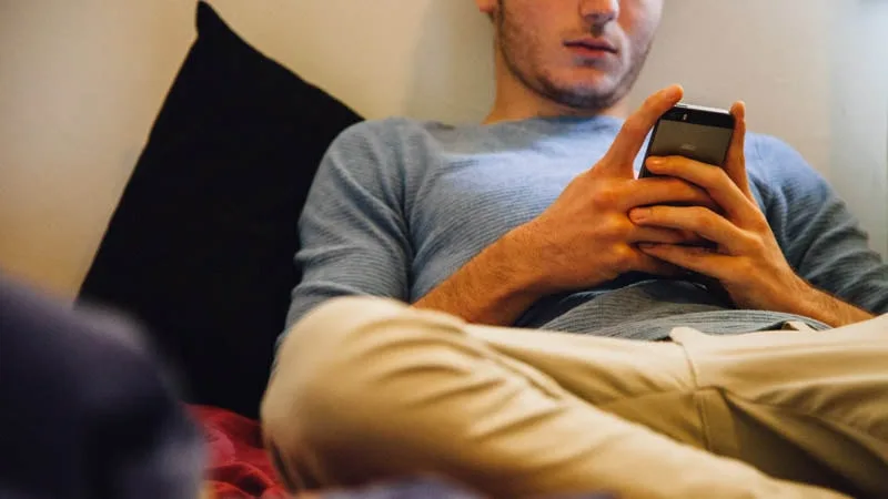 guy lying and looking at phone