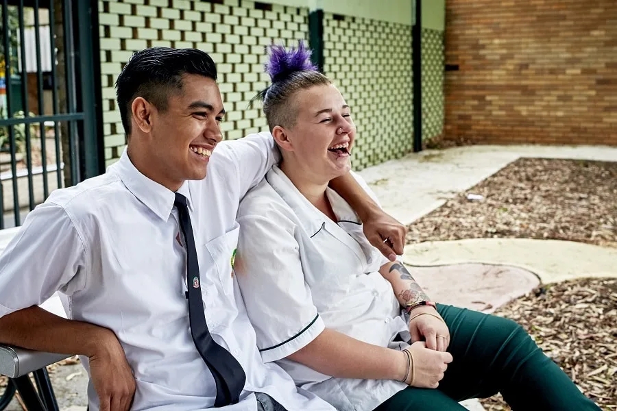 boy and girl in school uniforms laughing