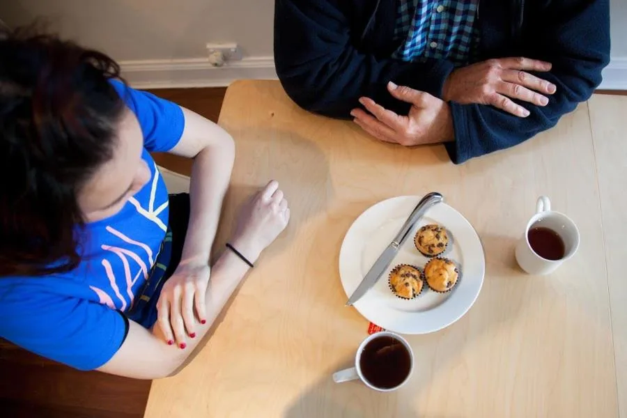 Aerial view of father and daughter seated at dining table