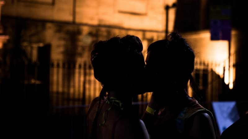 two people kissing outside in darkness