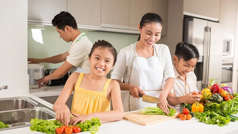 parents and two kids in the kitchen cooking