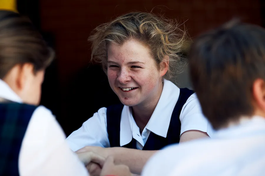 student smiling at school table