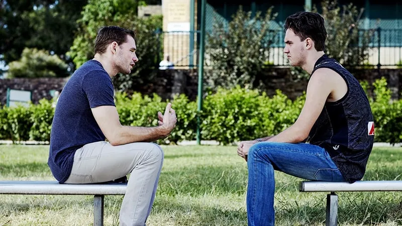 Man and boy talking on benches