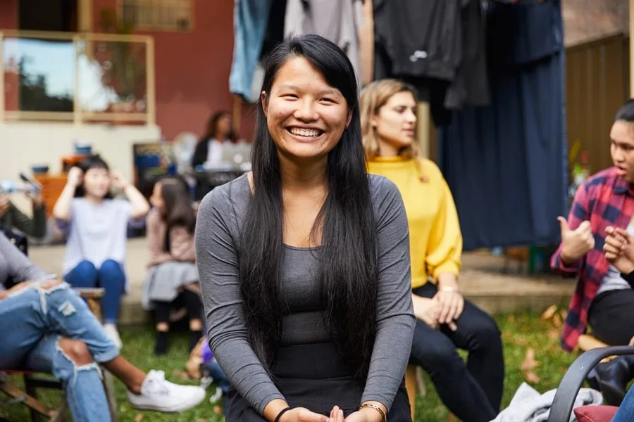 Girl sitting in group smiling at camera