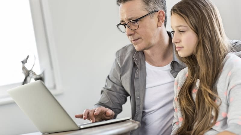 Father showing daughter something online