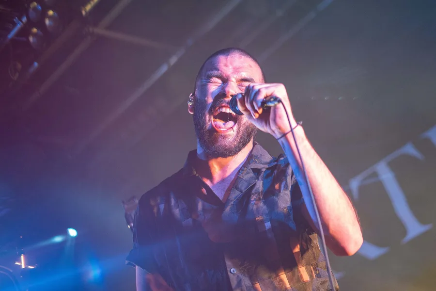 The lead singer of metalcore band Northlane sings into a microphone at a local gig in Albury