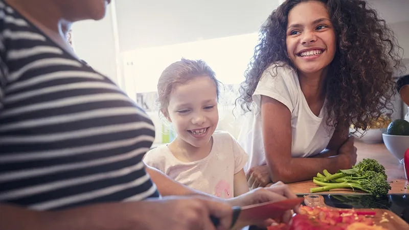 smiling kids preparing vetegables with parent