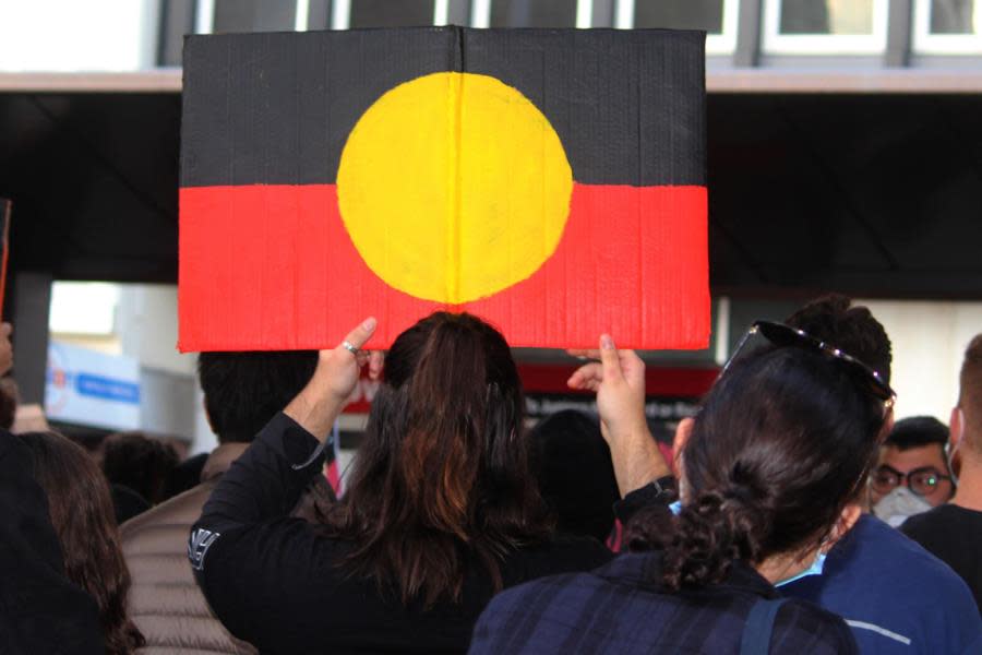 yound woman holding aboriginal flag