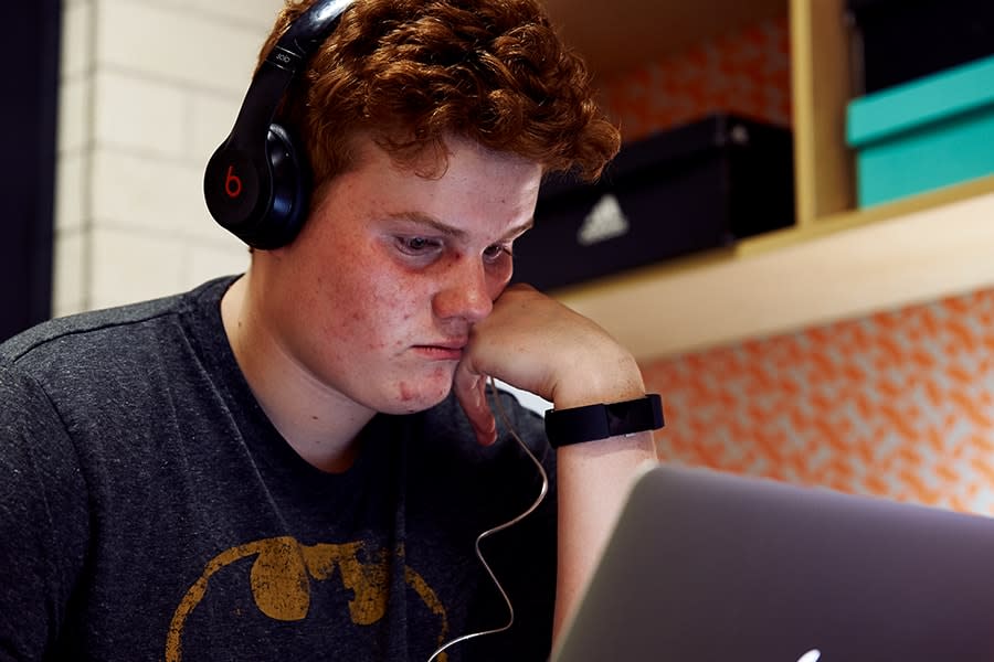 guy wearing headphones and looking at laptop