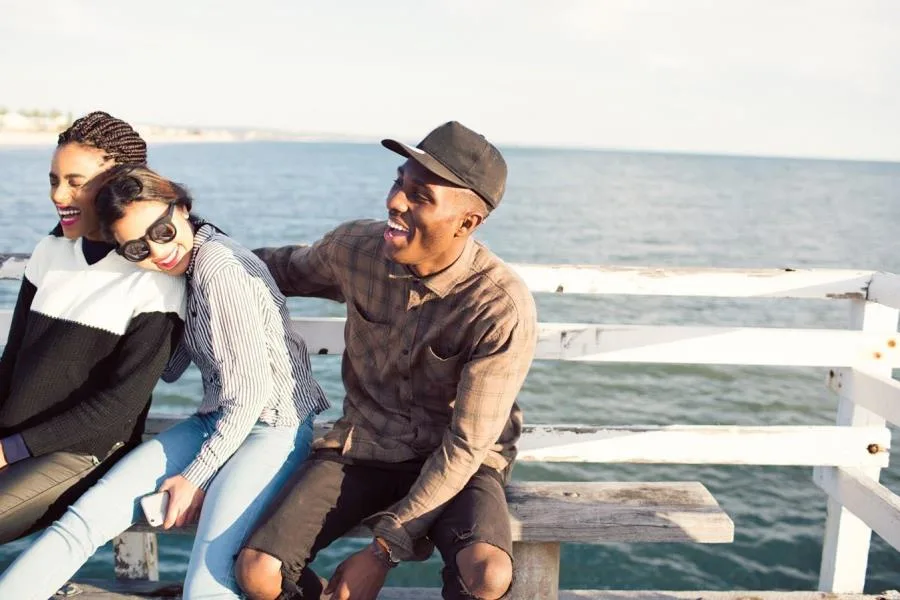 3 friends laughing on pier