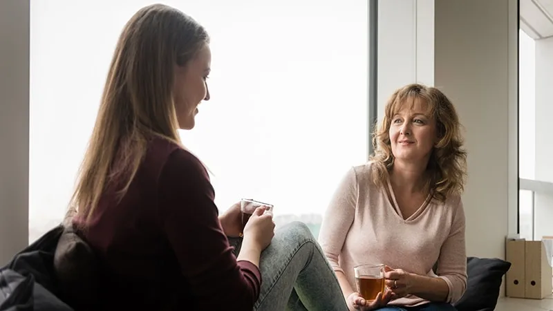 Mother and daughter talking and drinking tea