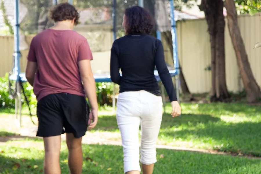 mother and son talking in backyard