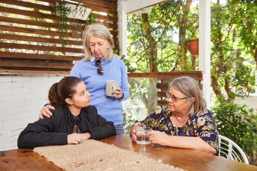teenage girl being supported by two women