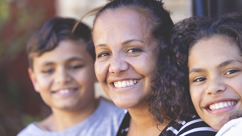 Aboriginal Torres Strait Islander mum smiling with two teenage kids