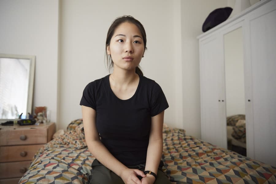 girl sitting on her bed looking at camera