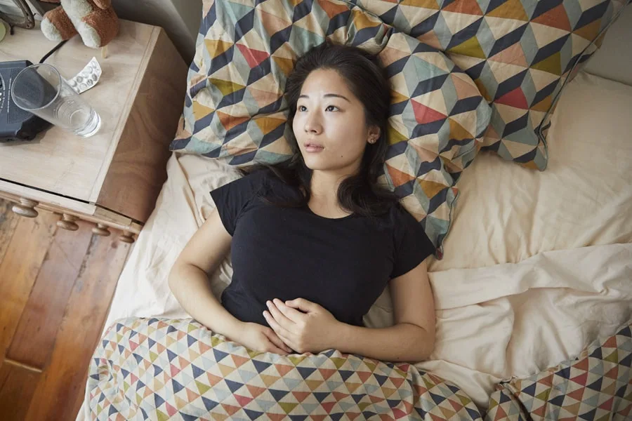 Girl in bed looking up at cieling