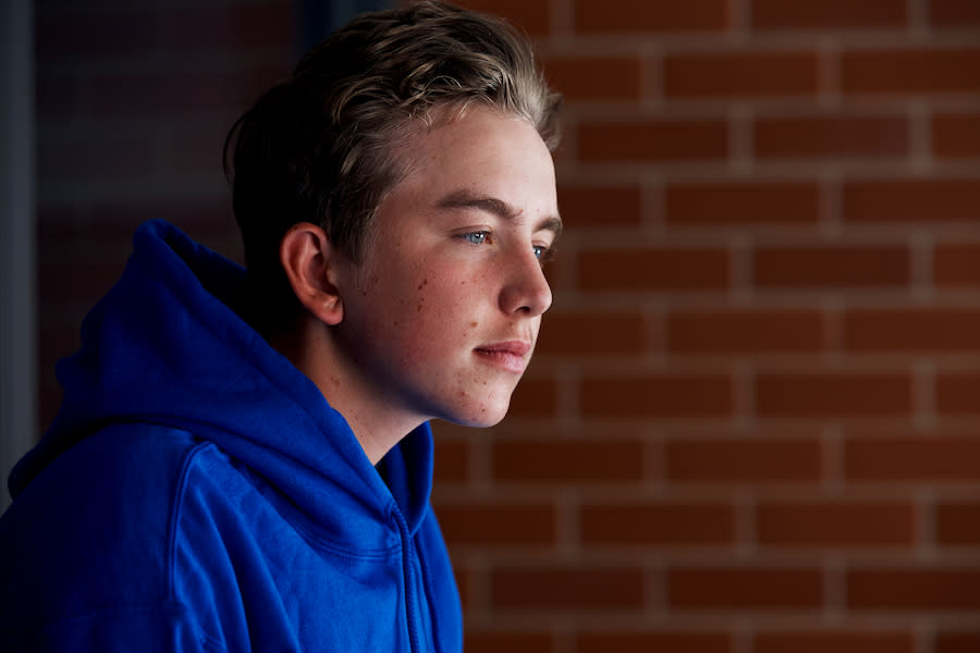 Image of a teen boy's side profile. He has a neutral expression and looks lost in thought.