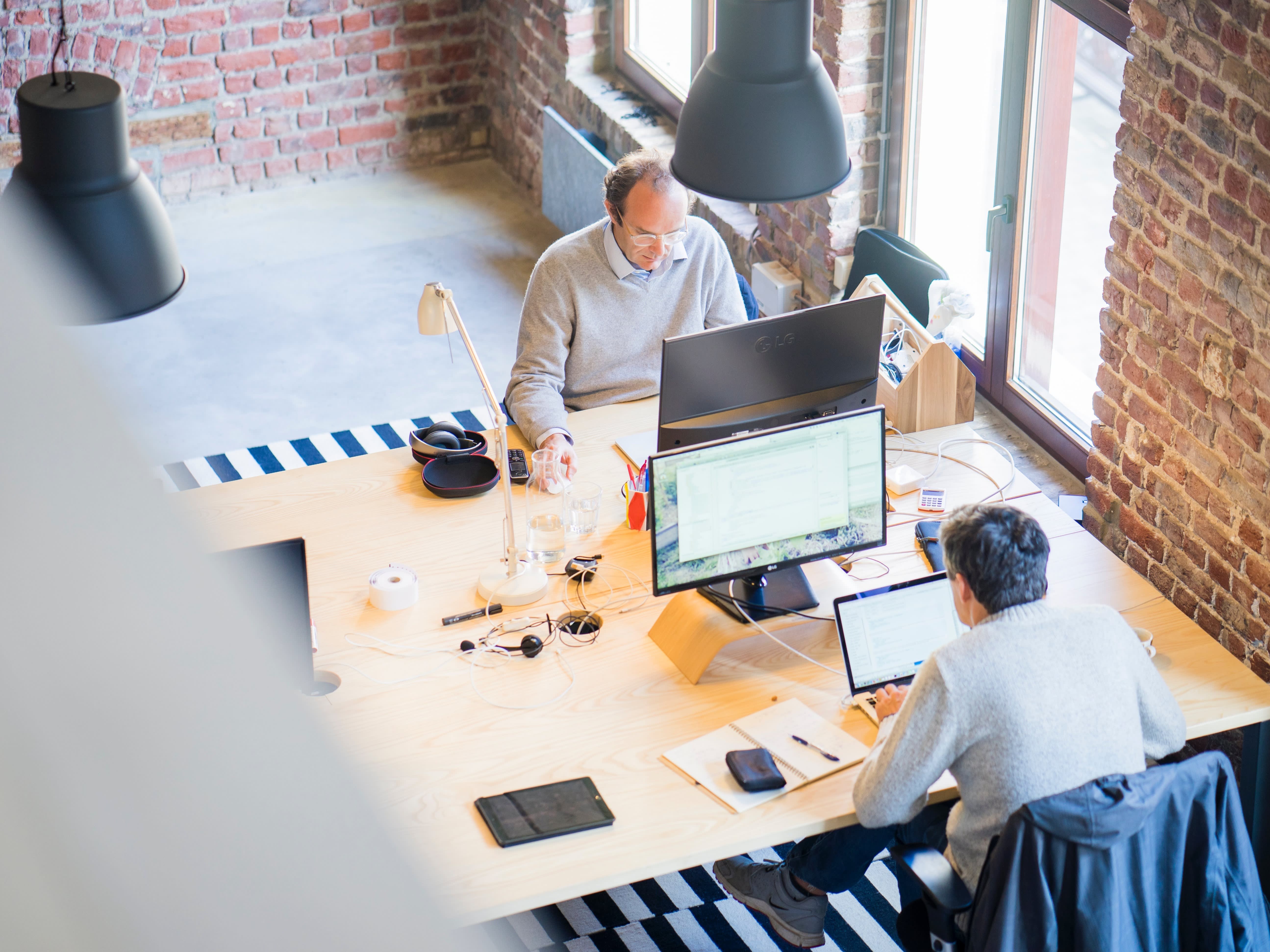 English speaking jobs: An office from birds-eye perspective looking at two men working in front of their screen.