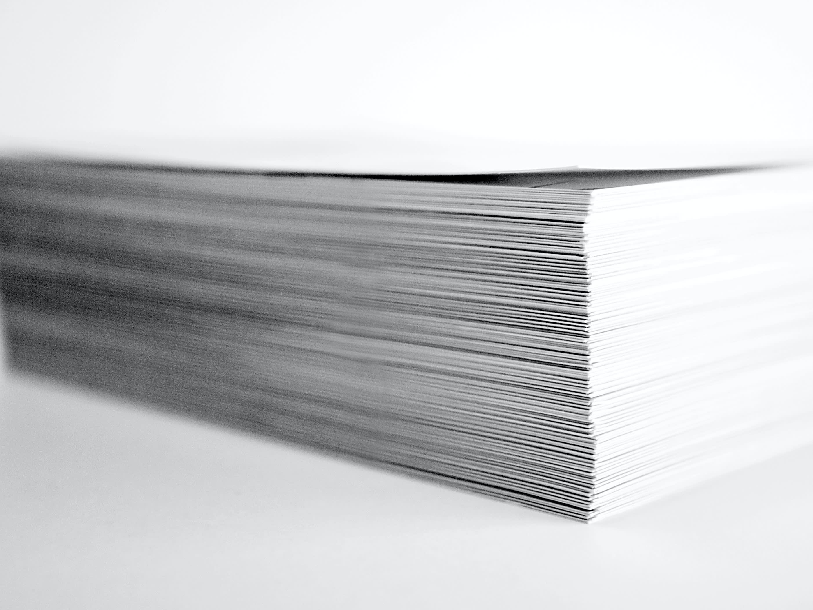 A black and white image of a pile of documents 