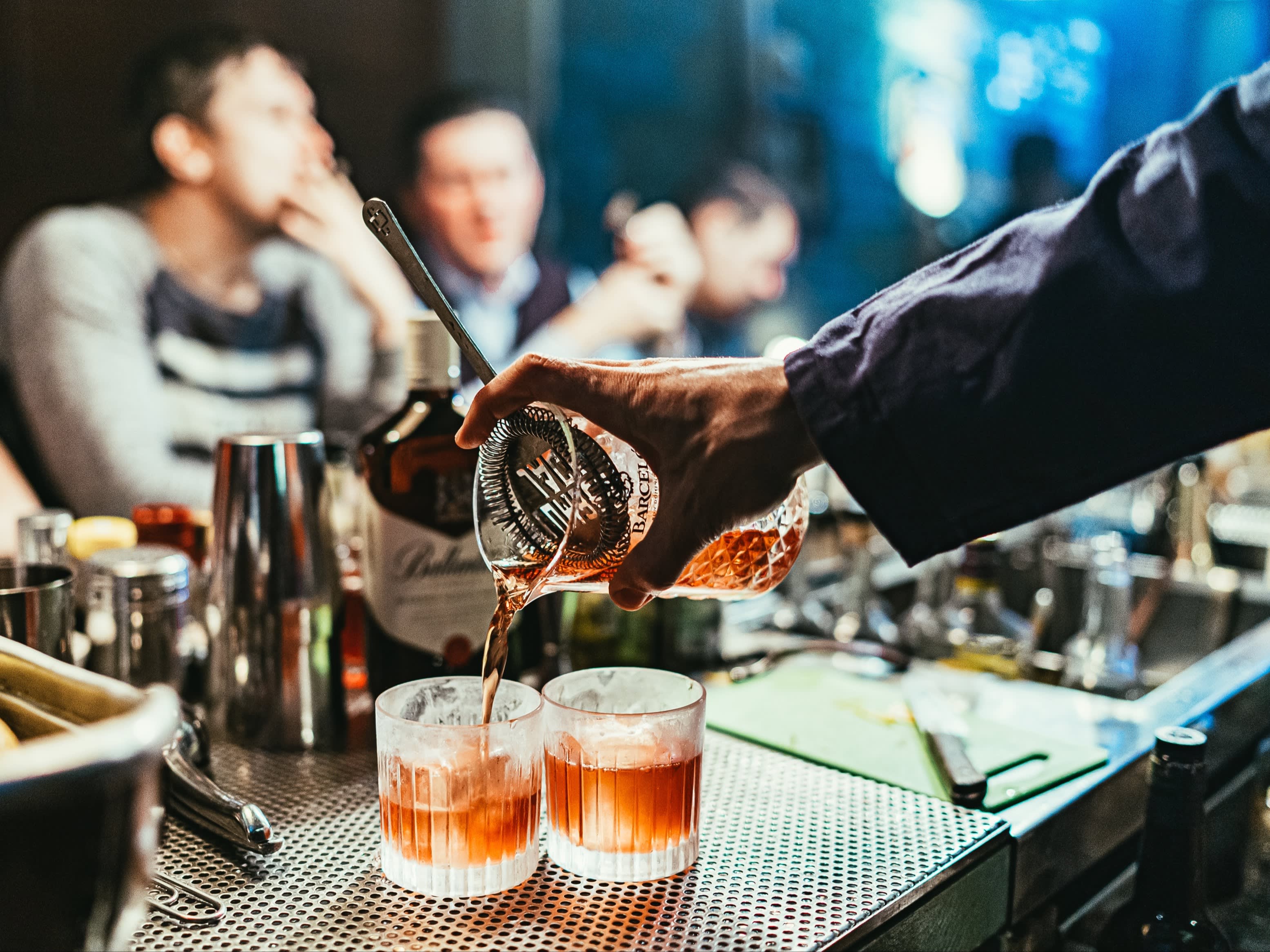 barmen pouring cocktail in glasses