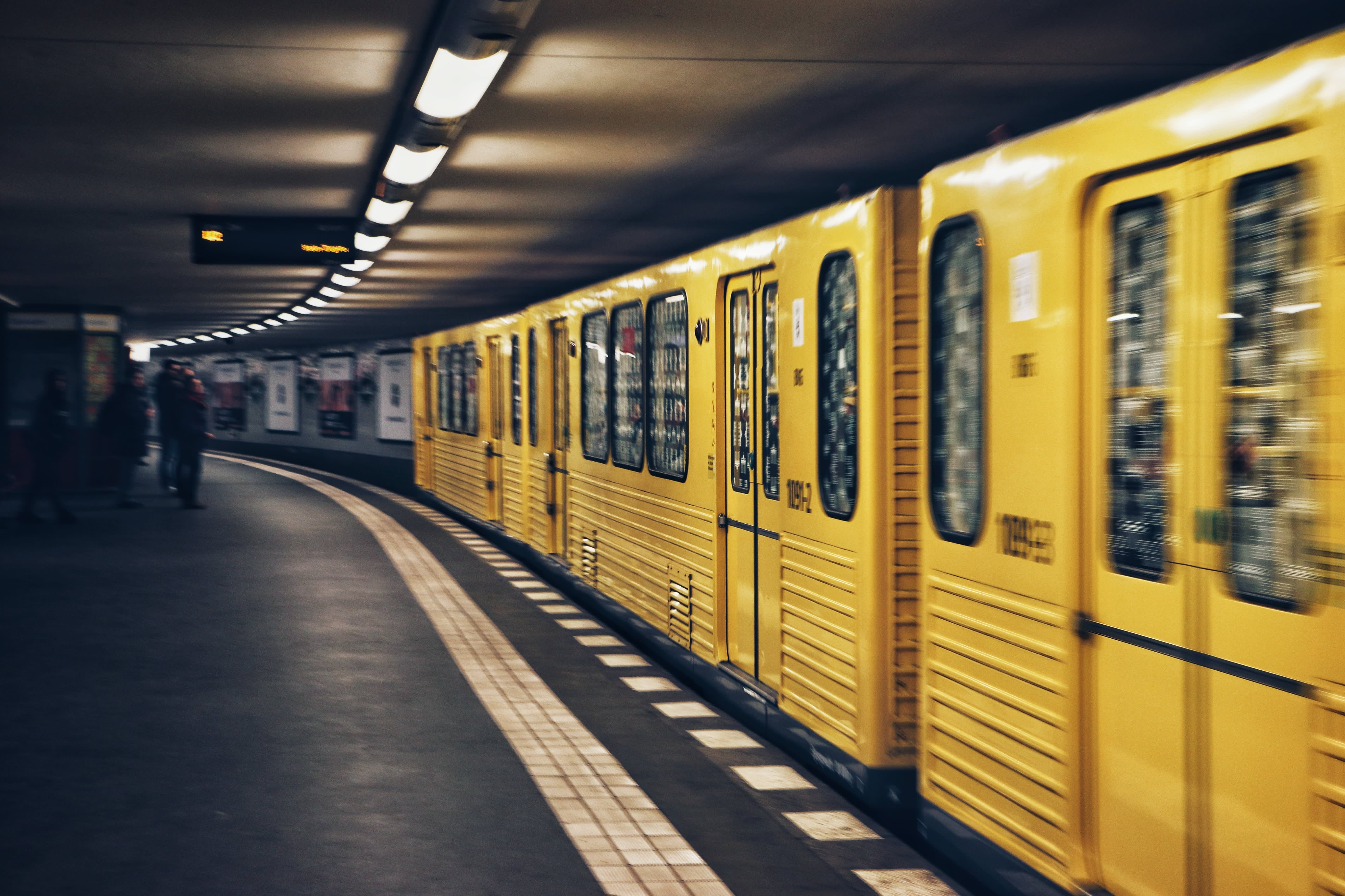 Berlin metro rushing by a station. Yellow BVG wagon.