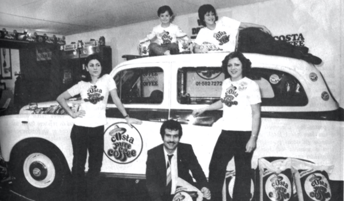 Photo of one of the Costa brothers and 4 of their team, in front and on top of one of the Costa Coffee White London Taxi Cabs, that used to deliver beans to the hotels.