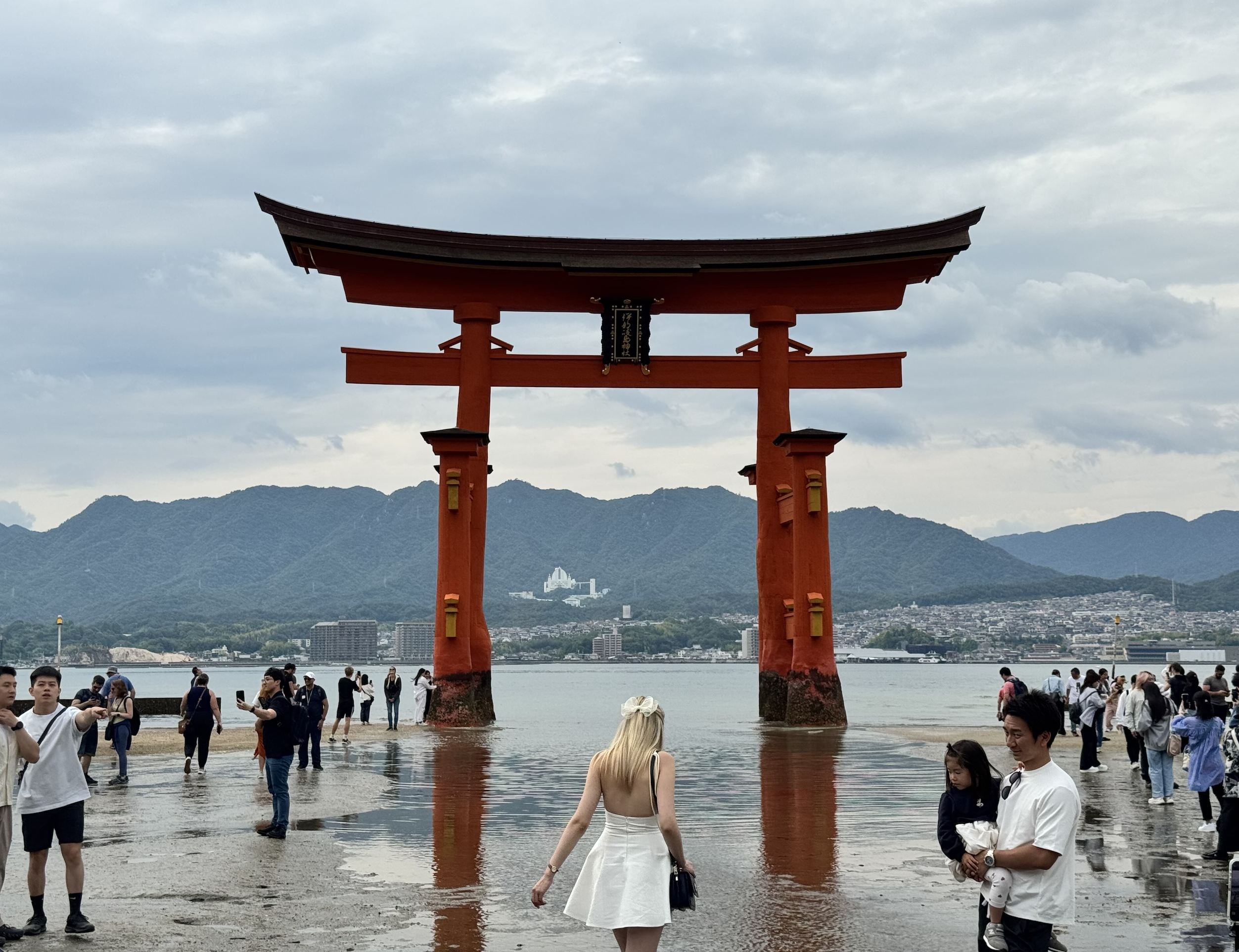 Suhe walks towards the vermilion torii gate of Itsukushima Shrine in Miyajima