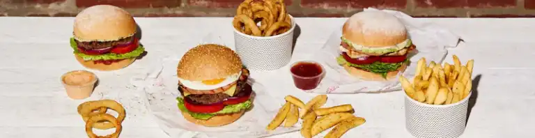Spread of burgers, chips and onion rings on a table