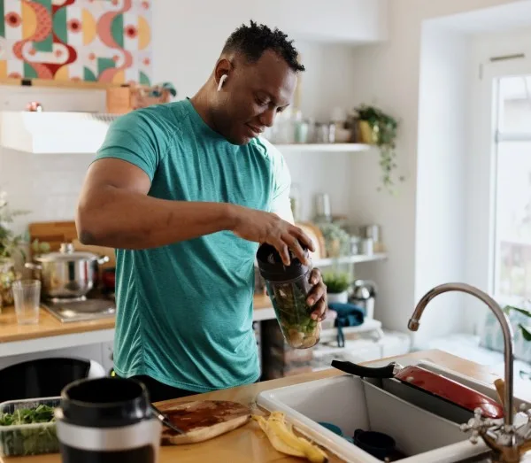 Man in kitchen over sink