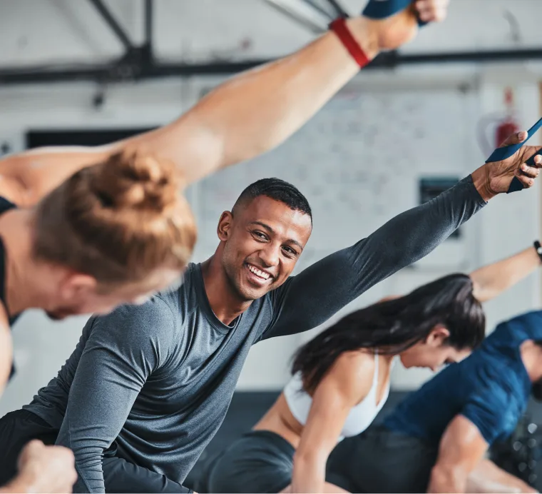 Certified Personal Trainer smiling and stretching with students