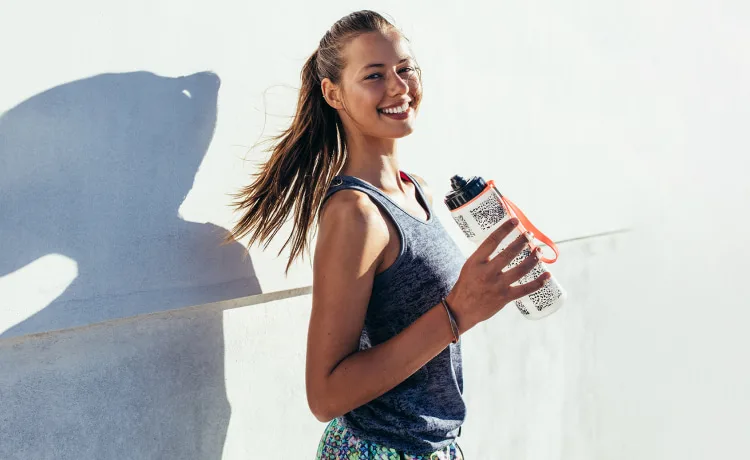 Weight Management Specialist smiling for a photo with her shadow behind her on a concrete wall